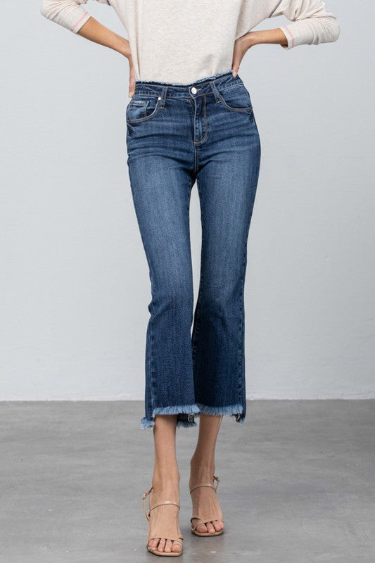 Dark blue bootcut crop jeans front close-up with frayed raw hem at ankles