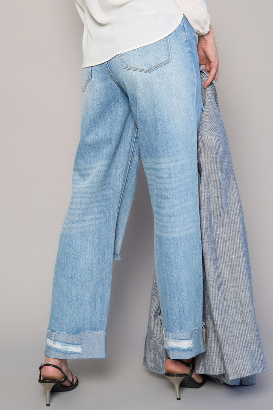 High-waist medium wash ripped straight jeans with faded panels and frayed cuff openings.