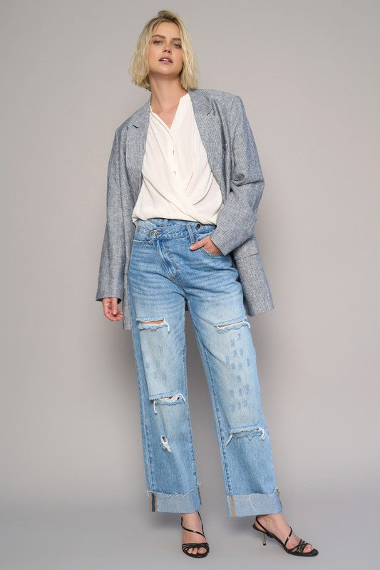 Medium wash high waist crossover ripped straight jeans with front knee rips and hem distress