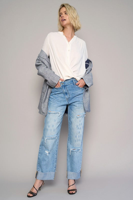 High-waist crossover ripped straight jeans, medium wash, patched knee rips and straight leg.