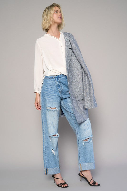 High-waist crossover ripped straight jeans, medium wash, with front-leg knee rips and rips at hem.