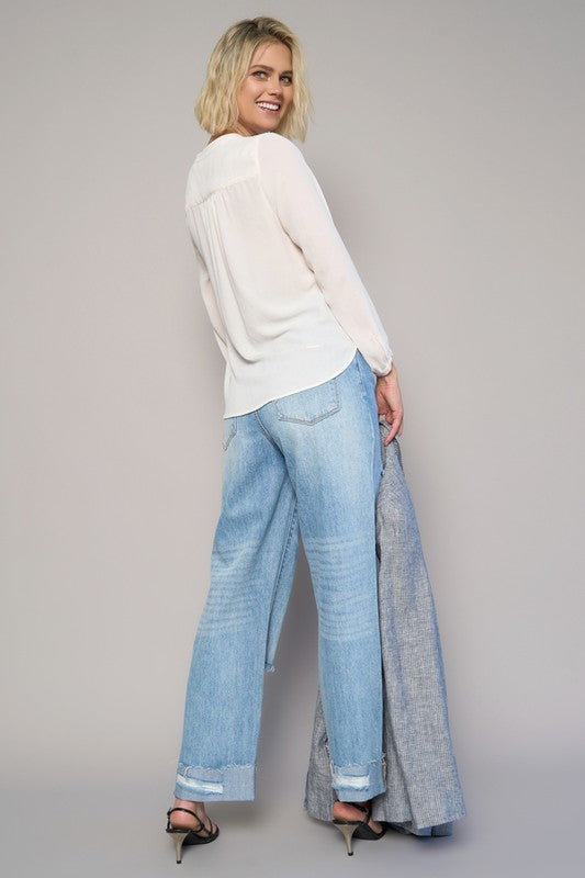 High-waist crossover ripped straight jeans in medium wash with straight leg and distressed back pockets.