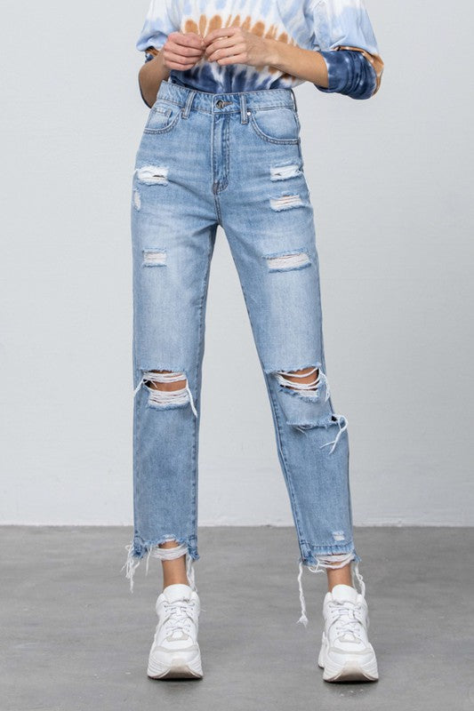 High-waist denim jeans in medium wash, front knee rips, frayed ankle hems