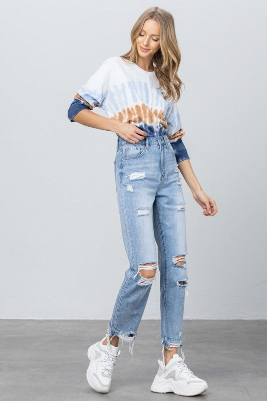 Medium wash high-waist jeans with distressed knees and dangling frayed ankle hems