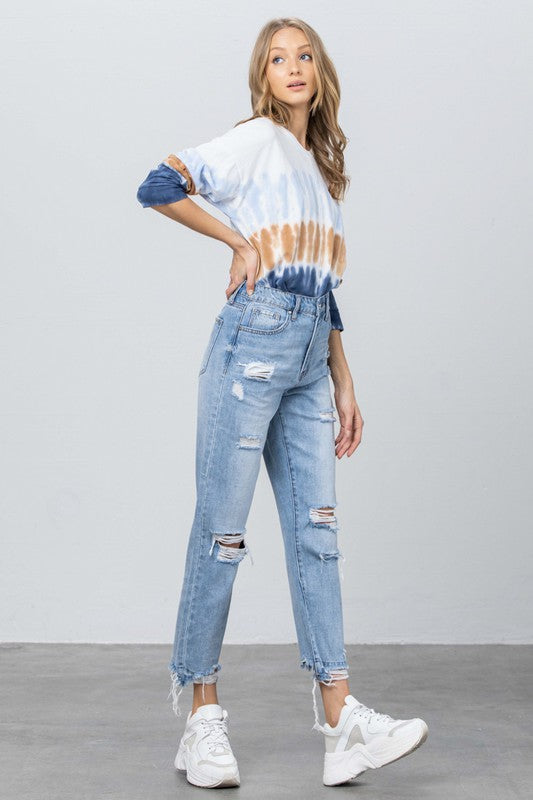 High-rise ripped girlfriend jeans, medium blue denim, shredded hems over ankle