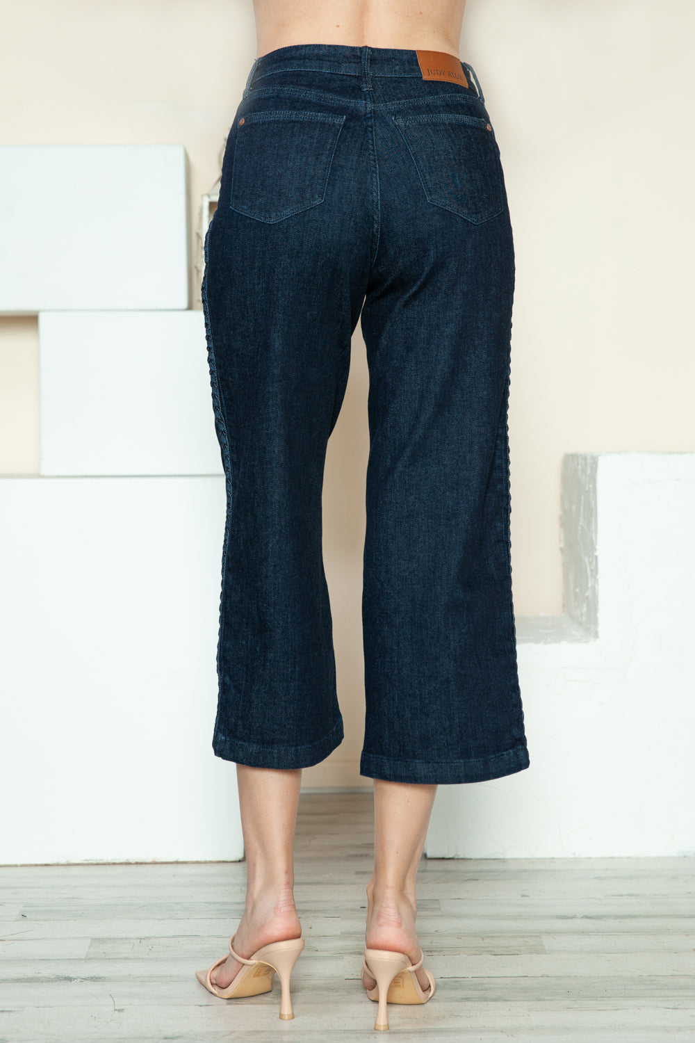 Dark blue wide-leg crop jeans back view with yoke seam and belt loops