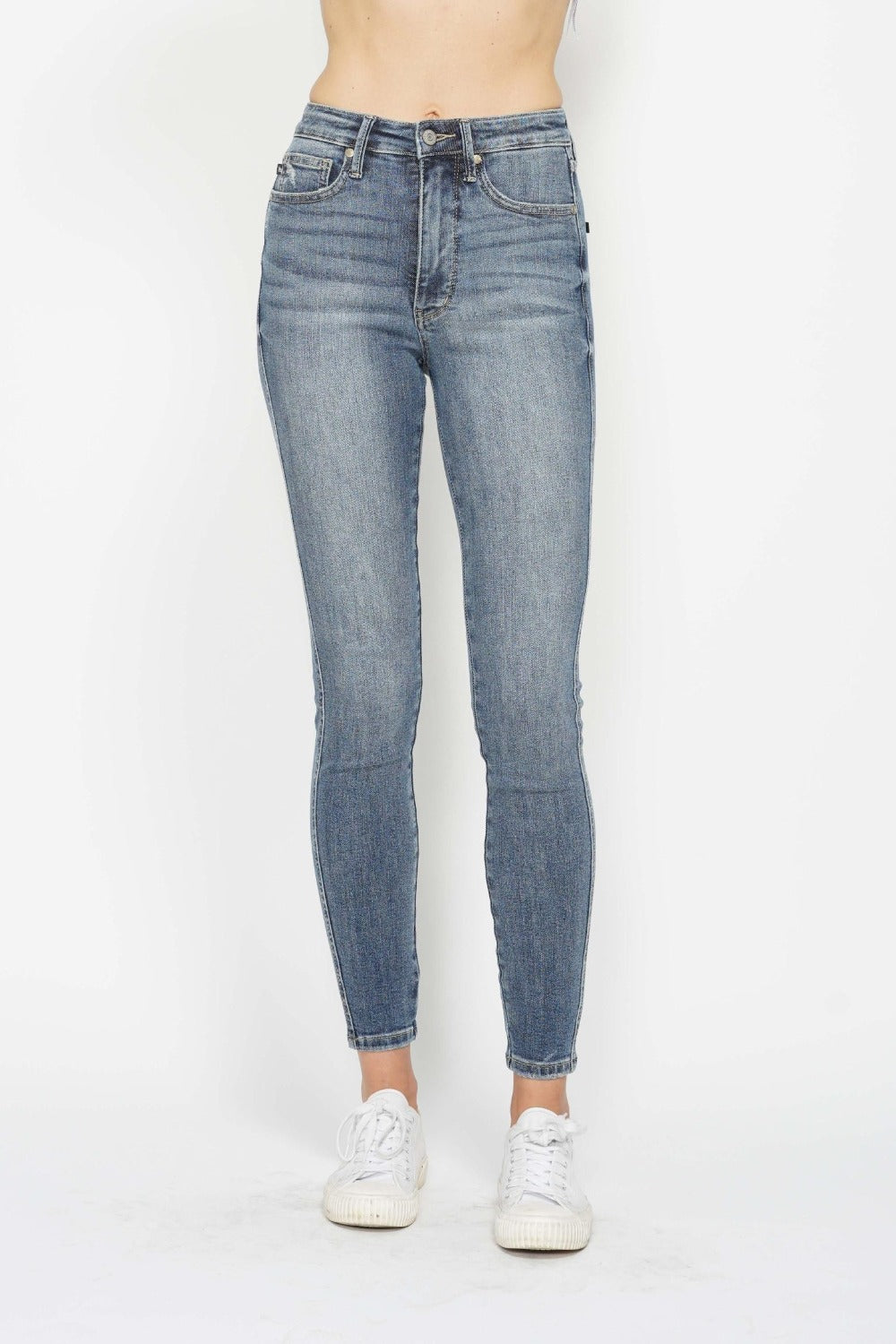 Medium wash skinny jeans, front view with zipper fly and belt loops