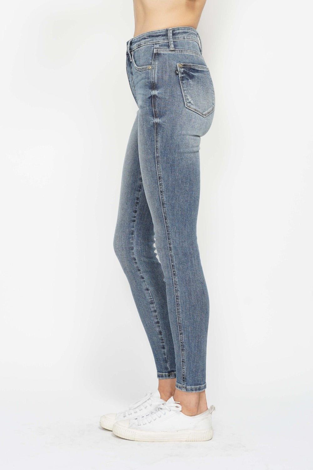 Medium wash skinny jeans, side back view with rear pocket detail
