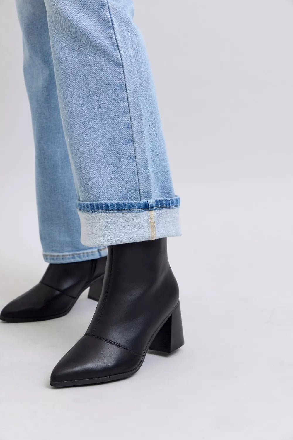 Light blue bootcut jeans with cuffed hem, paired with black ankle boots
