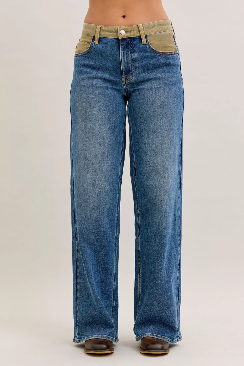 Medium blue straight jeans with olive corduroy waistband and button closure, front view