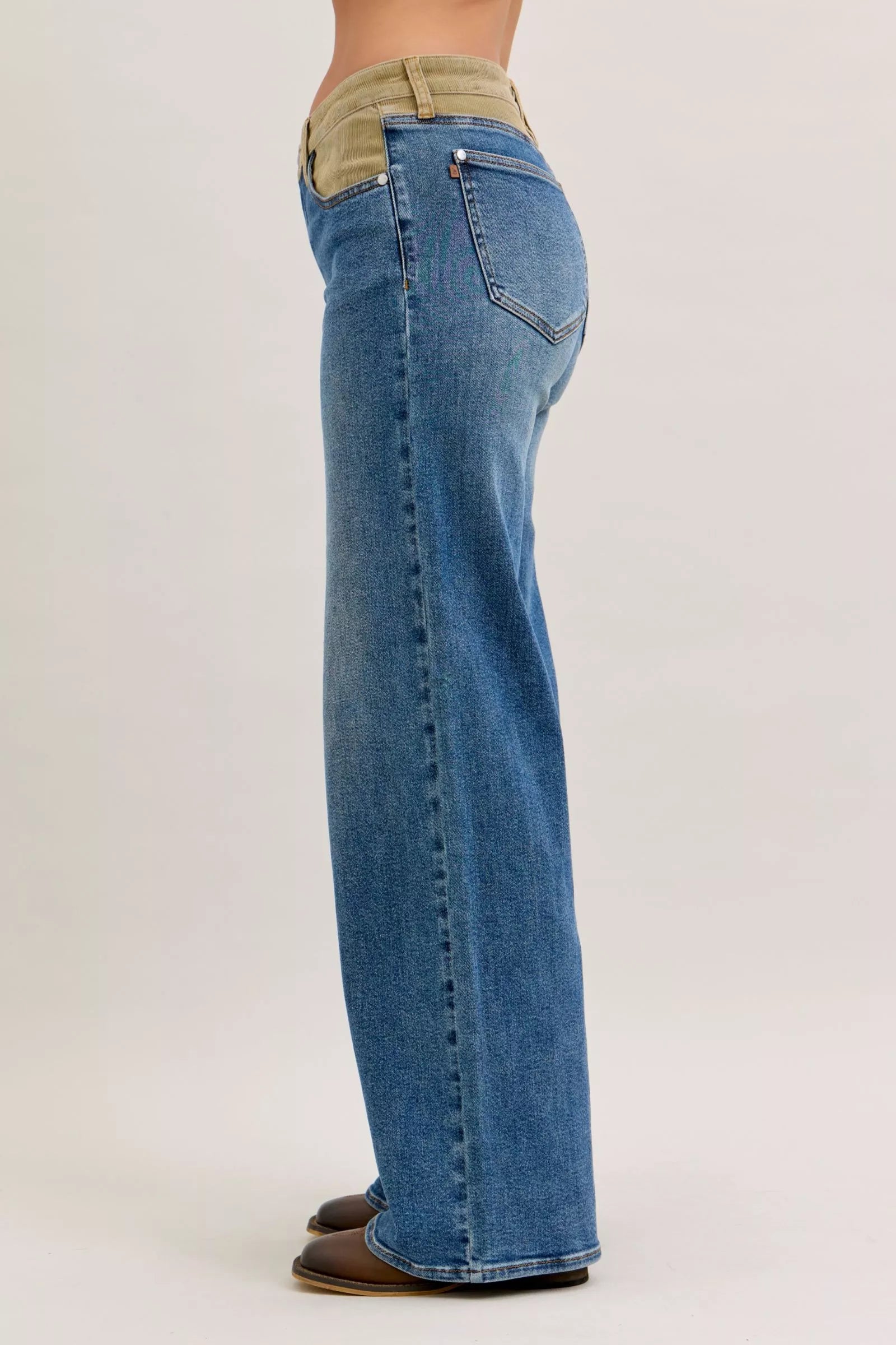 Medium blue jeans with corduroy waistband, back side view near back pocket