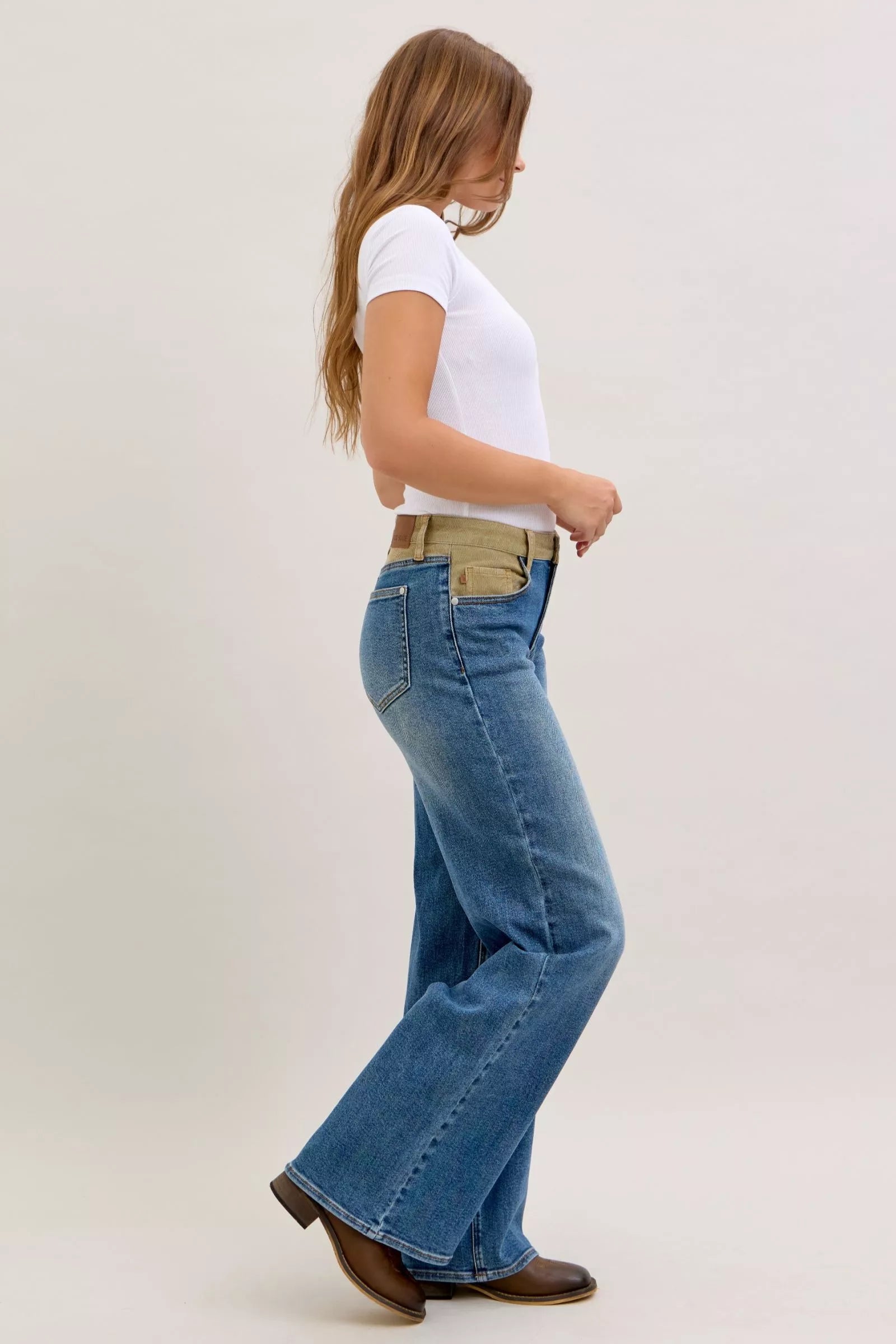 Medium blue straight jeans with corduroy waist, walking side view