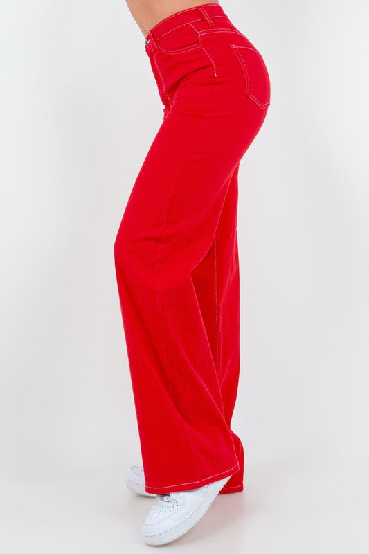 Red high-rise wide-leg jeans, side view with belt loops and stitched seams