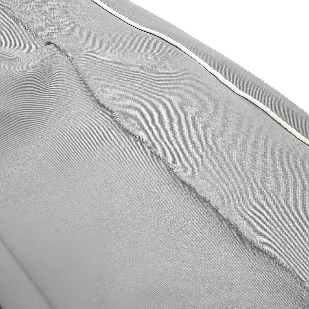Close-up of grey pant fabric with white side piping stripe