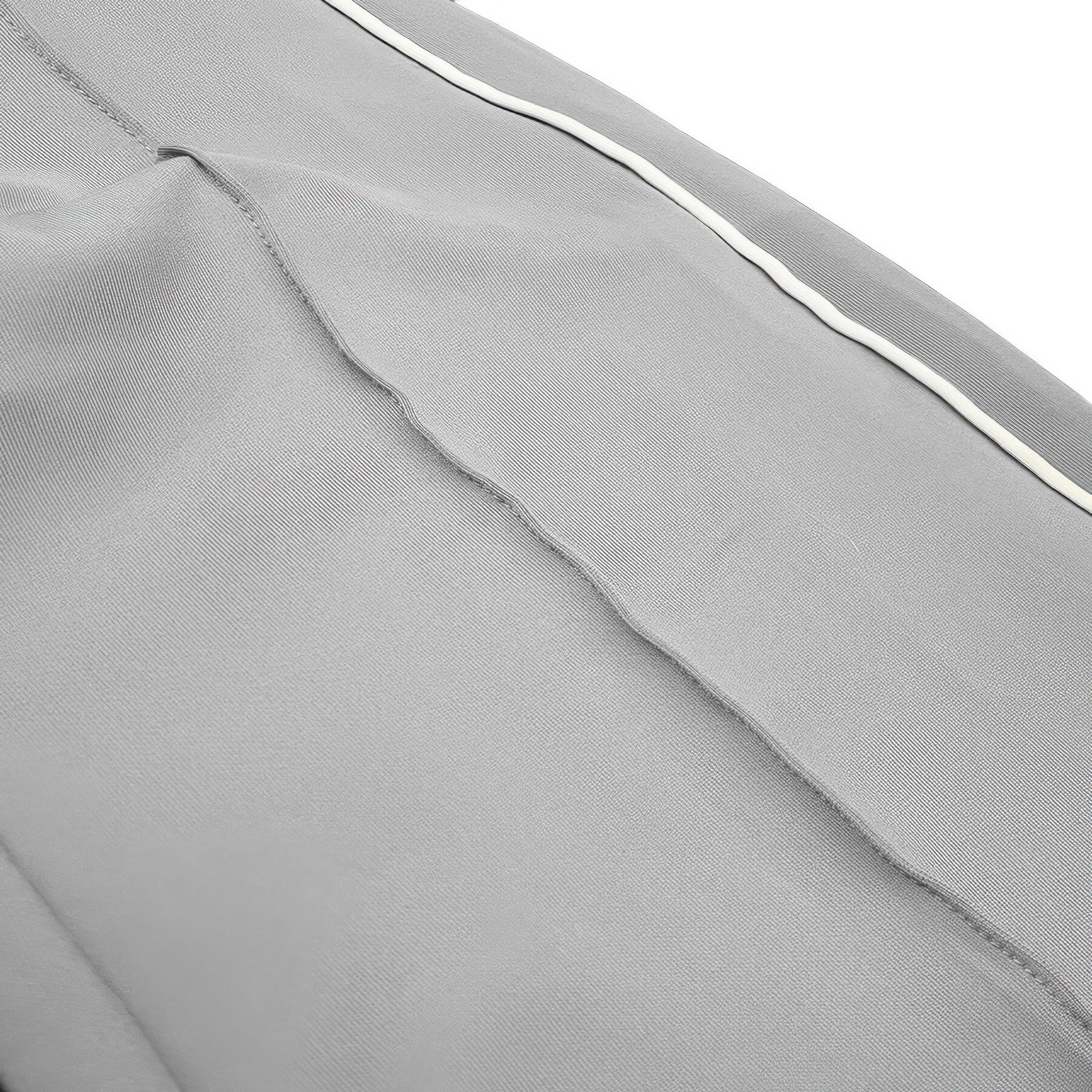 Close-up of grey pant fabric with white side piping stripe