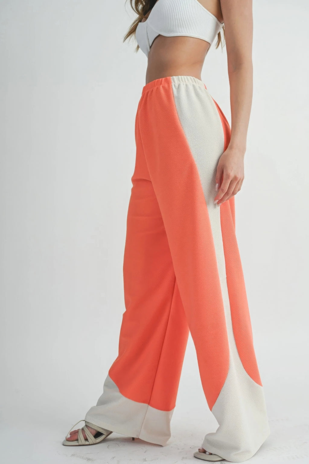 Wide-leg pants in coral with sweeping light side panel and relaxed fit from elastic waist.
