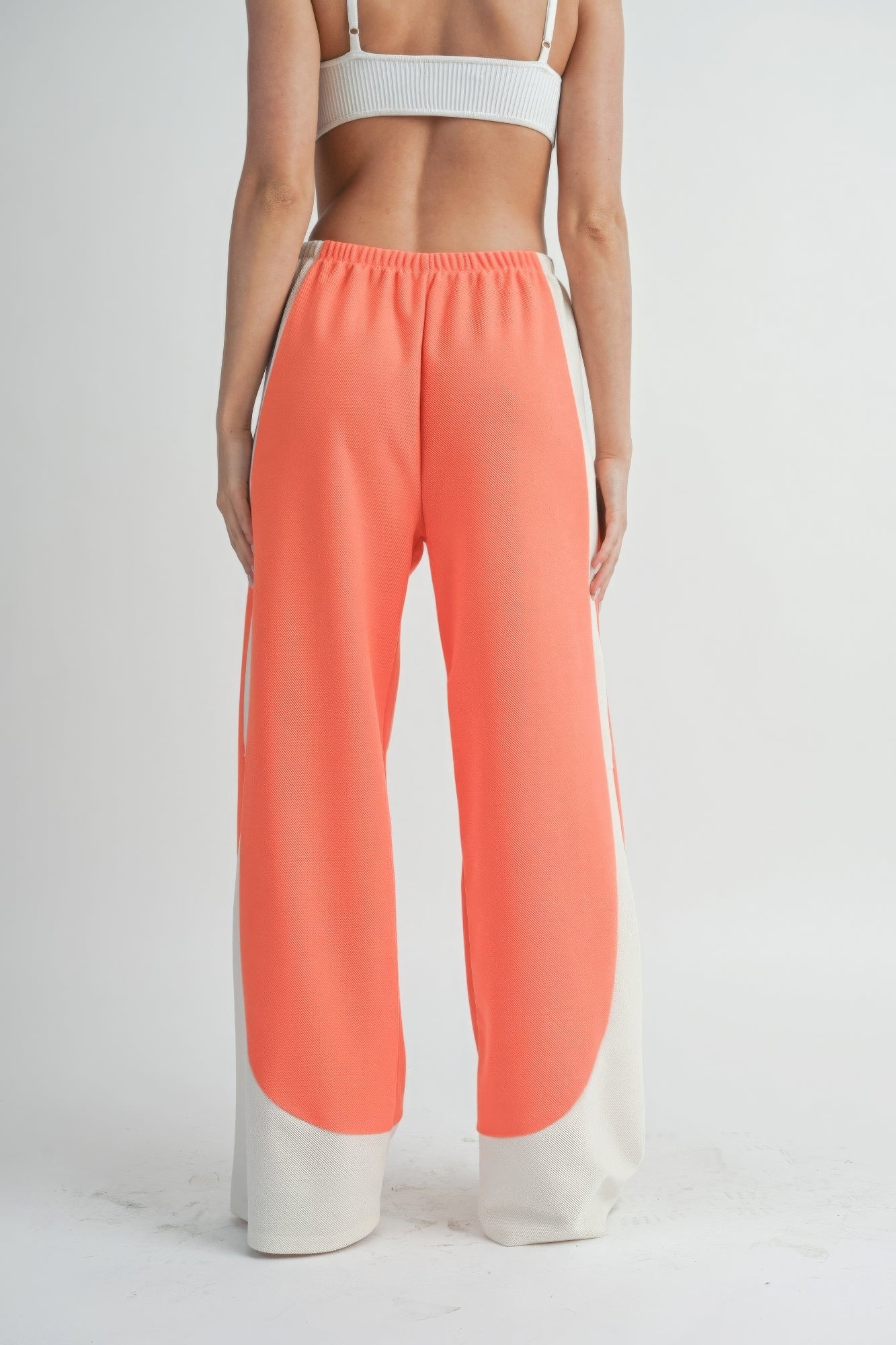 Two-Toned wide-leg pants, coral body with light contrast stripe at hem, elastic waist.