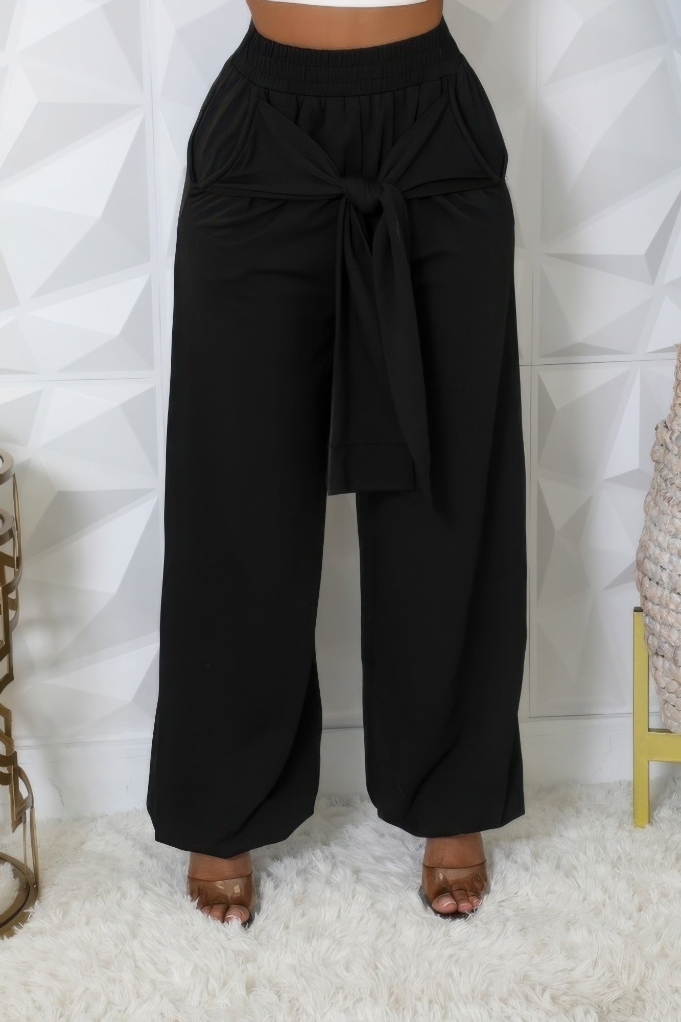 Black high-waist stretch pants, wide-leg silhouette with tied waist at front