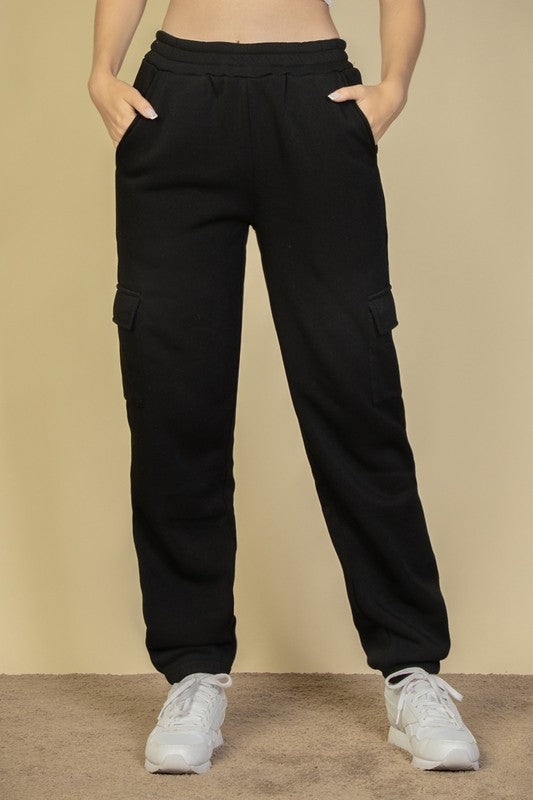Black drawstring waist sweatpants with side cargo pockets and relaxed tapered legs