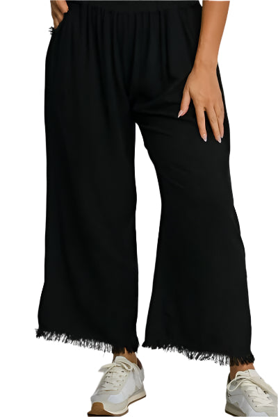 Black wide-leg trousers with elastic waist, draped legs, fringe at cuffs