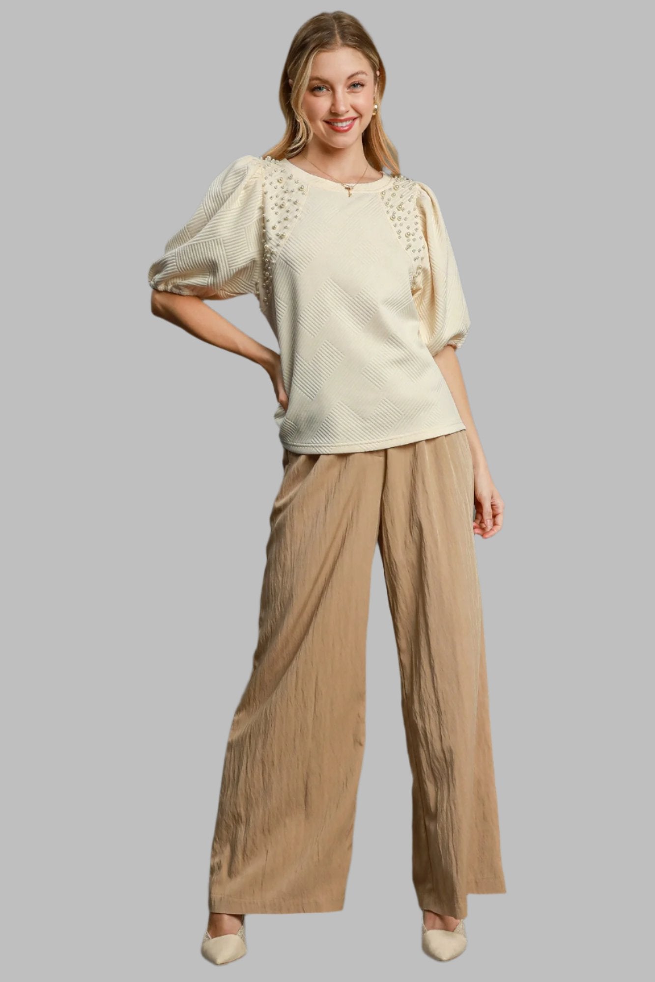 Cream knit puff-sleeve top with pearl beaded neckline; hip-length