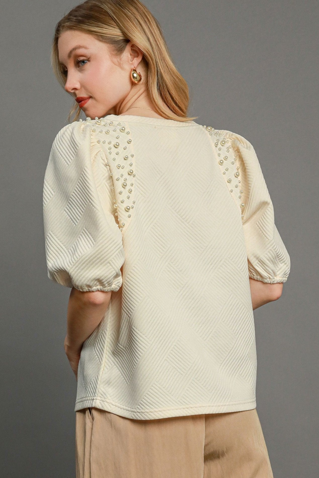 Cream knit top, back view: pearl-lined yoke and gathered puff sleeves