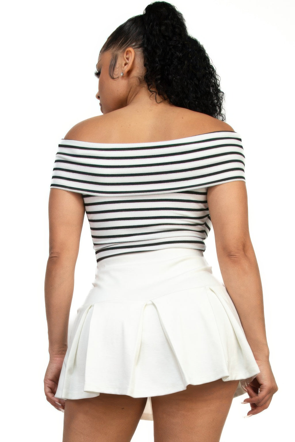 Back view of off-shoulder striped crop top and white pleated mini skirt