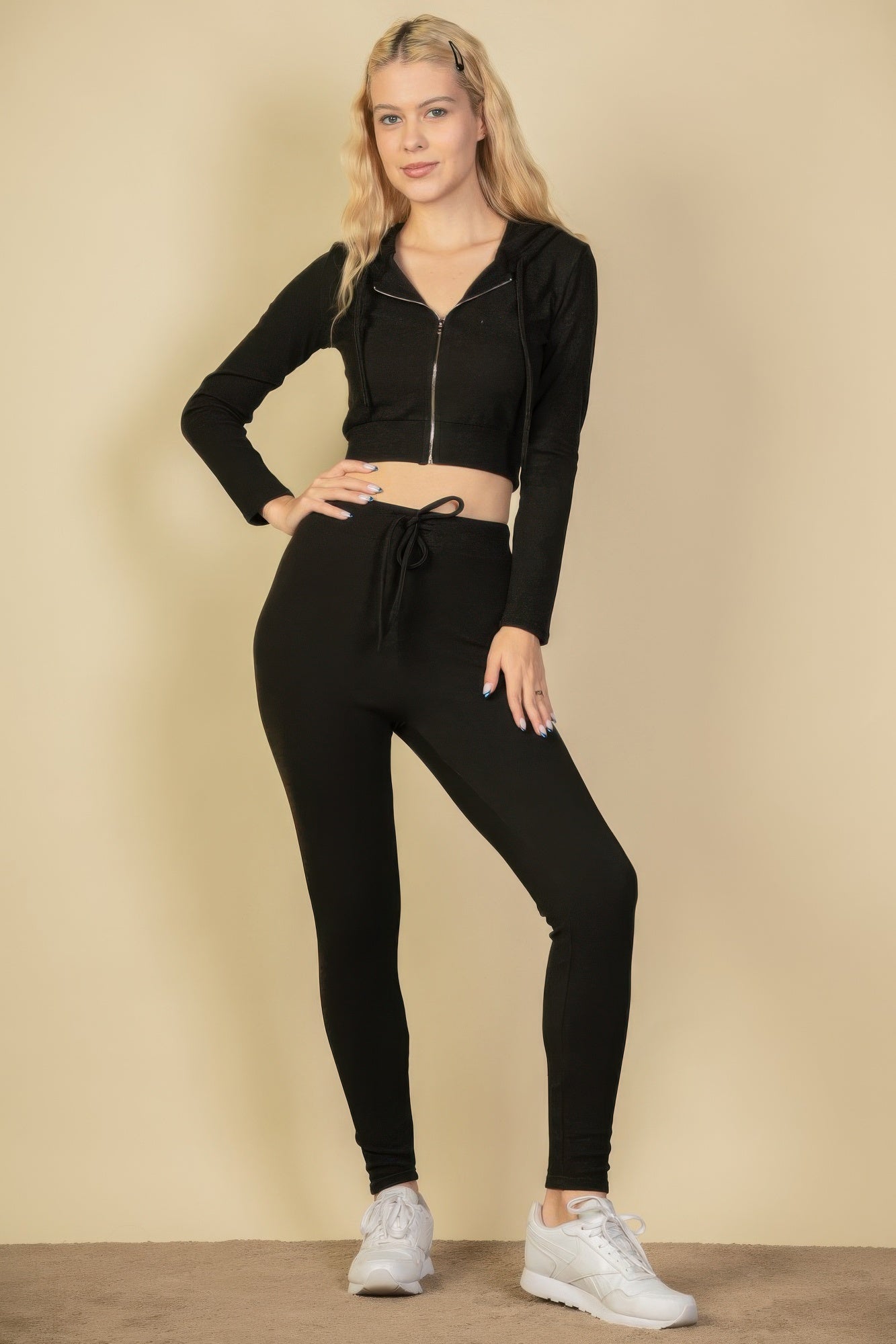 Black zip-up cropped hoodie with drawstring hood and front zipper, full front view