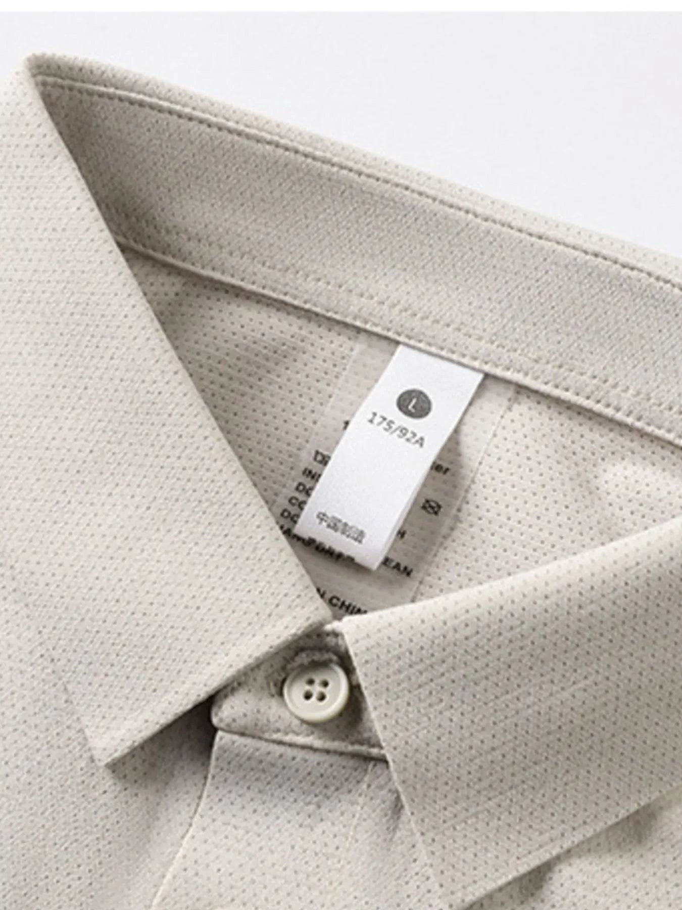 Mocha polo shirt collar and placket detail with white buttons