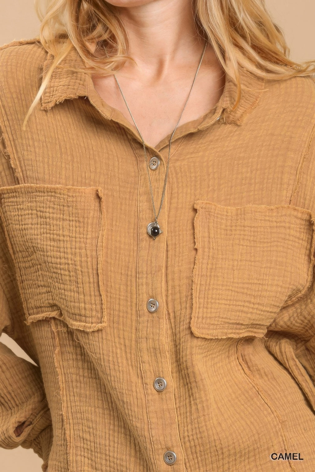 Camel button-down top close-up: two chest pockets and button front