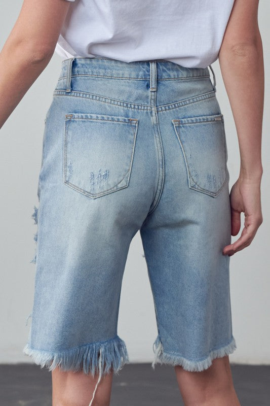 High-rise denim bermuda shorts, back view with patch pockets and frayed hem