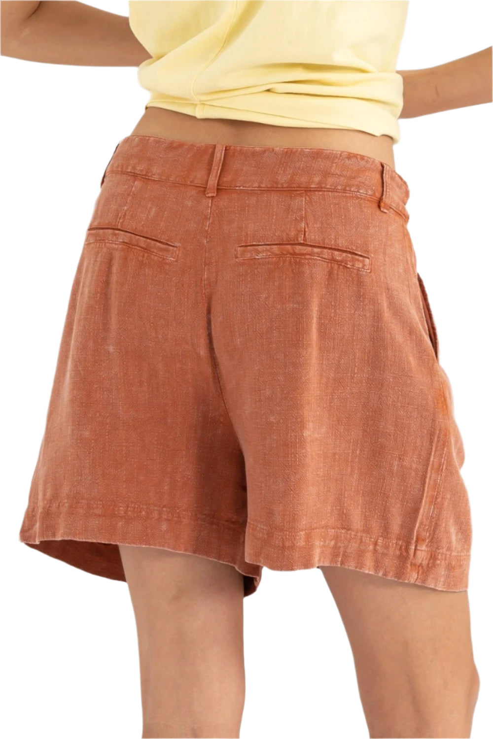 Rear view: high-waist pleated linen shorts in baked clay, size Medium