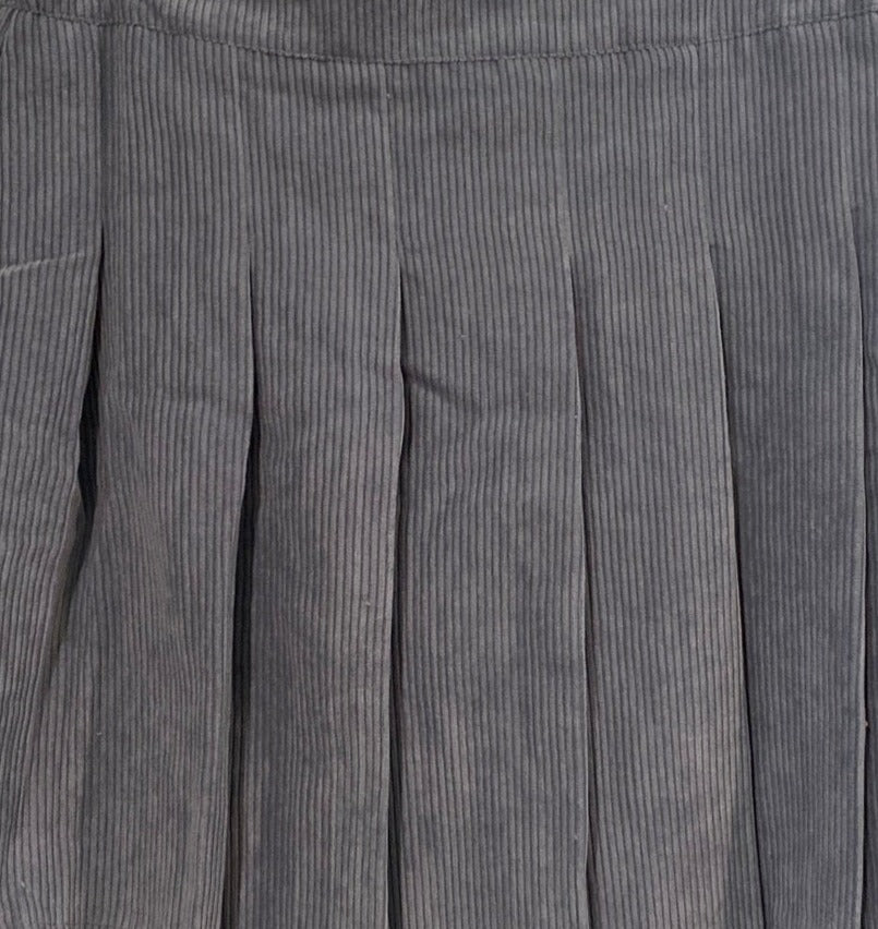 Blue corduroy fabric close-up with pleated panels and vertical ridges