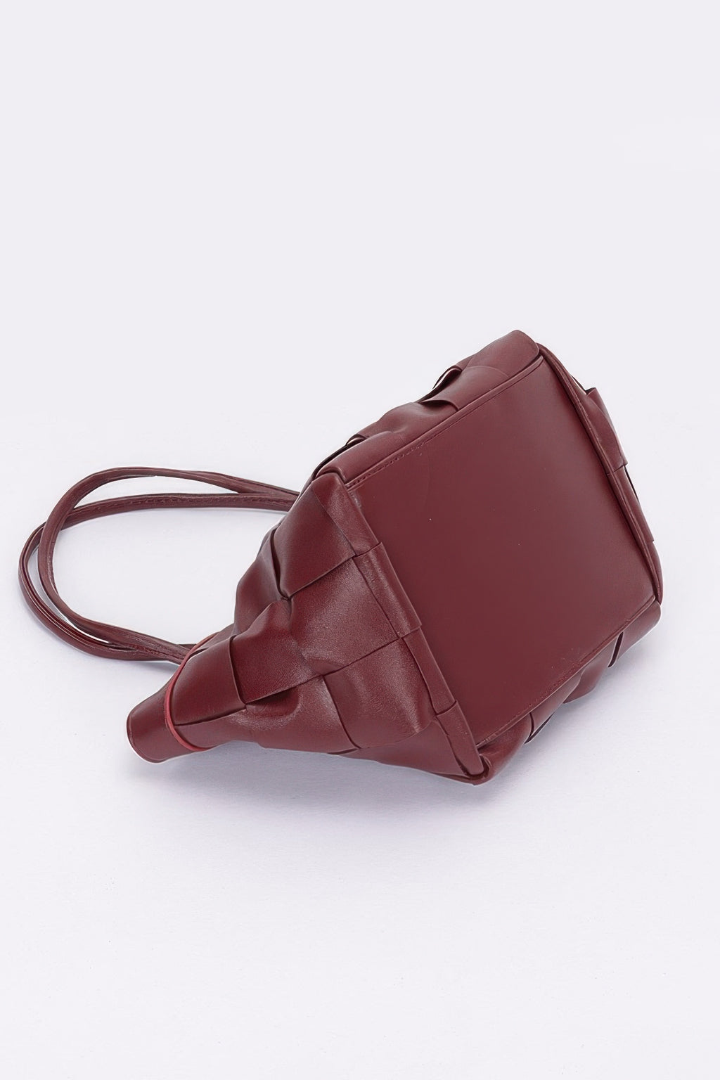 Burgundy faux leather braided tote bag side view with square panels and crossbody strap