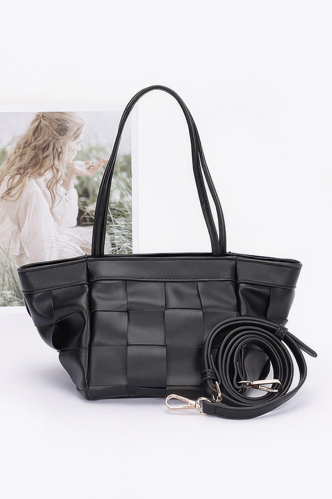 Black faux leather braided tote bag with woven square paneling and matching crossbody strap