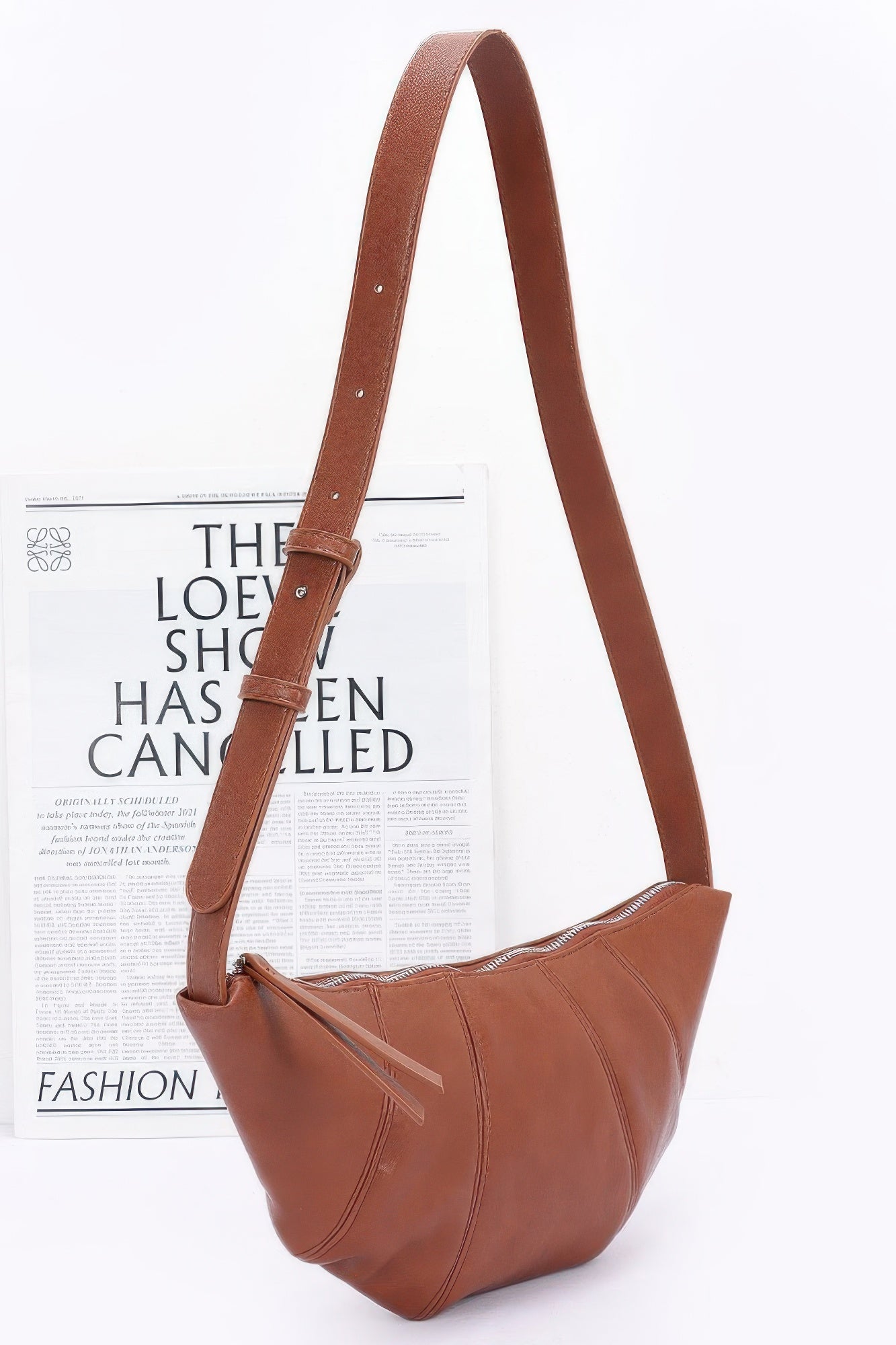 Rust-brown faux leather croissant bag with long shoulder strap and zip-top