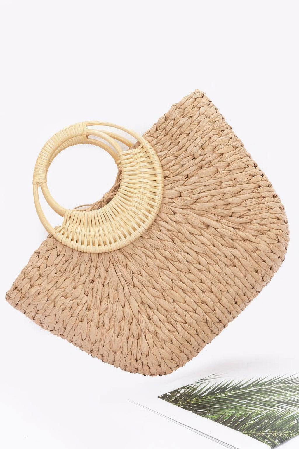 Khaki faux straw tote bag angled view with round bamboo handle loop