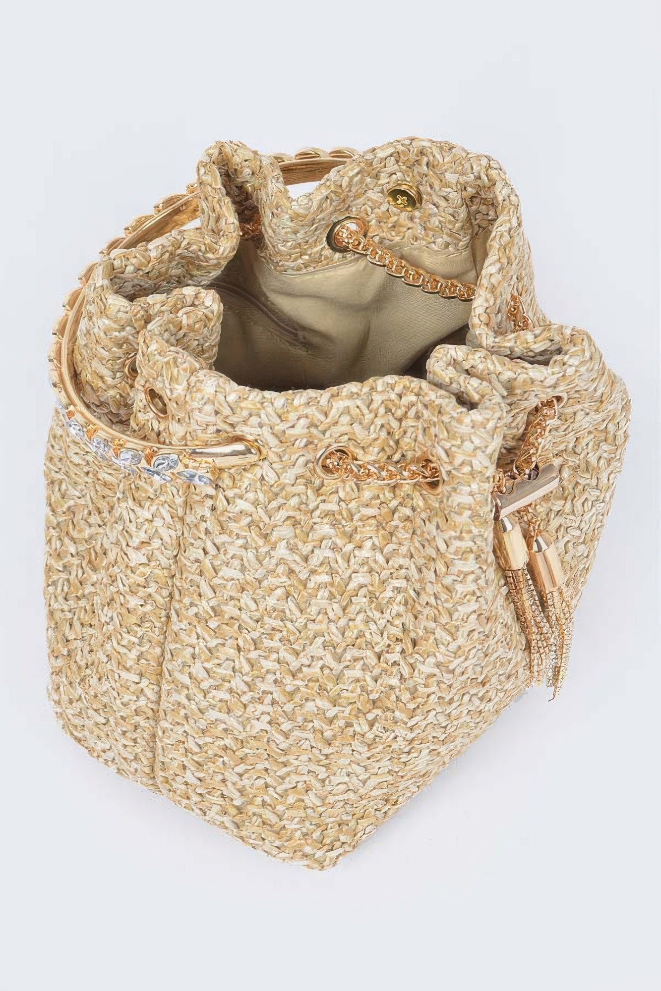 Interior view of faux straw bucket bag with fabric lining and gold chain