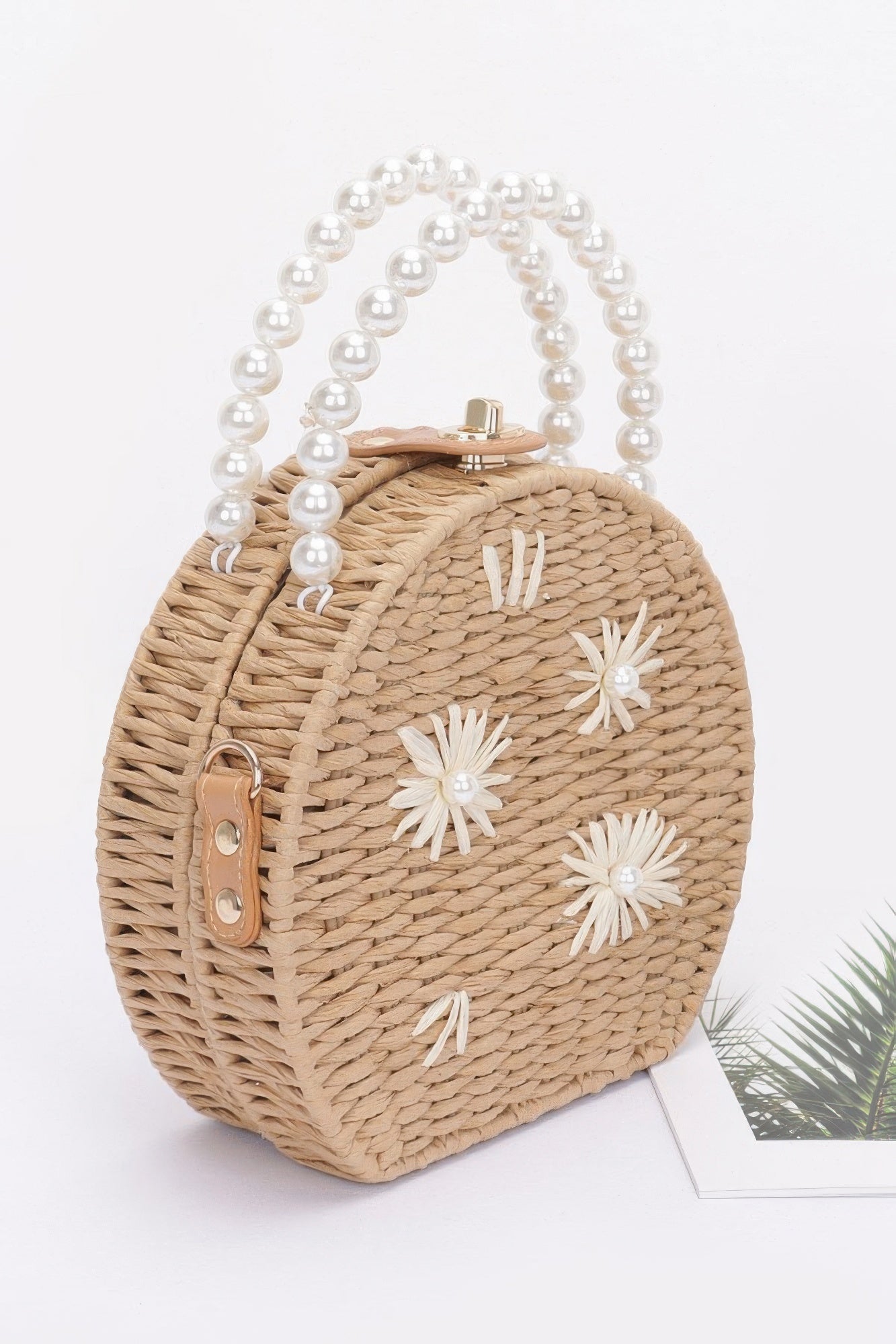 Round faux straw clutch with pearl handle and clasp, white flower details, khaki