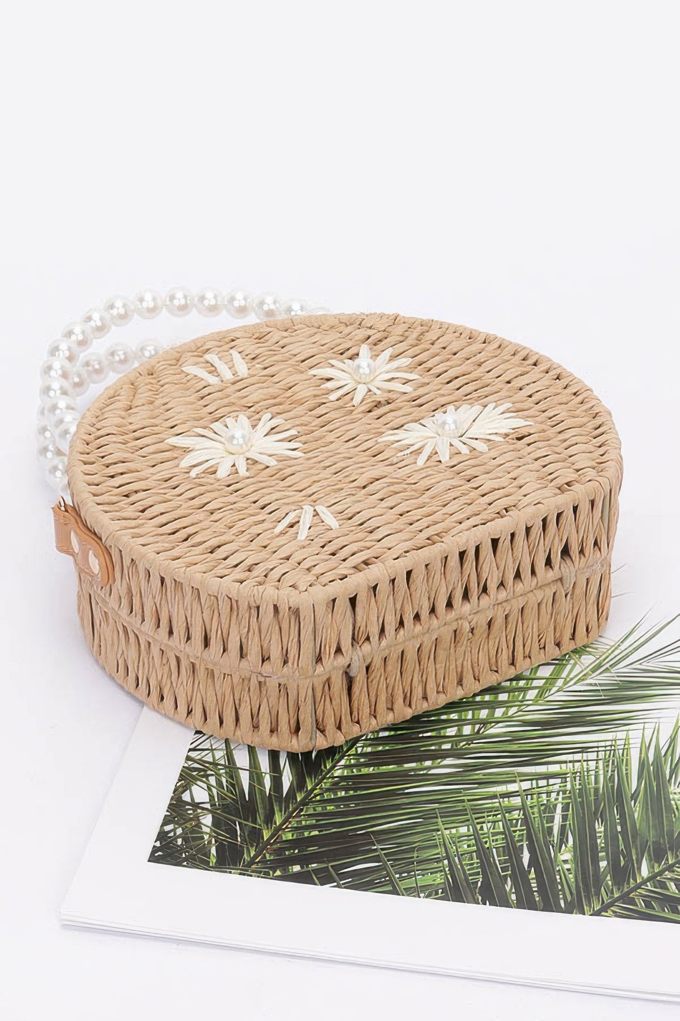 Faux straw clutch with pearl trim and top clasp, fringe edge, white flower appliqués, khaki