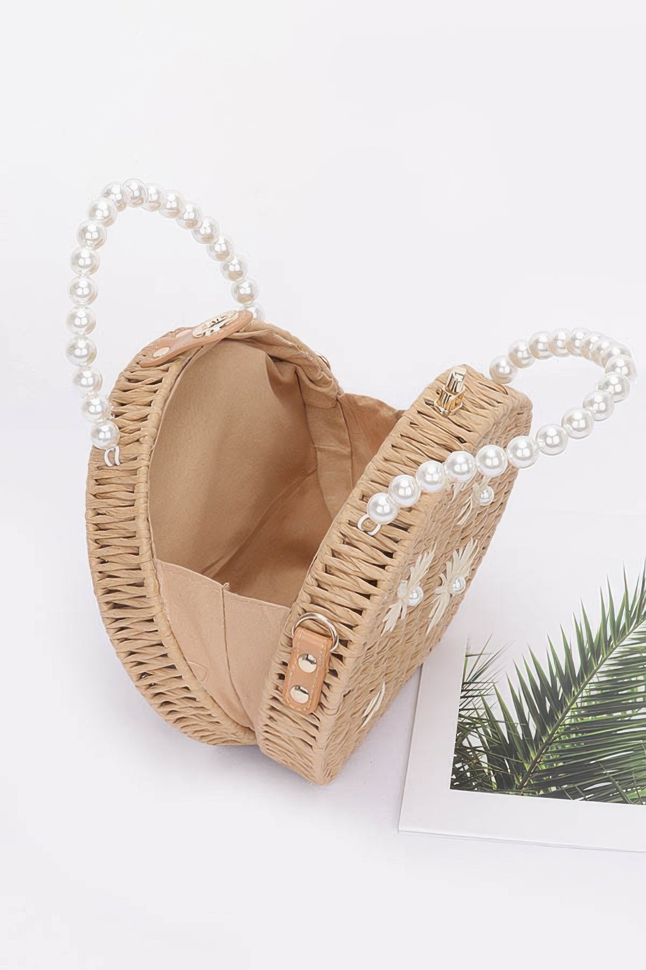 Faux straw clutch open view with pearl handles, top clasp, khaki interior lining