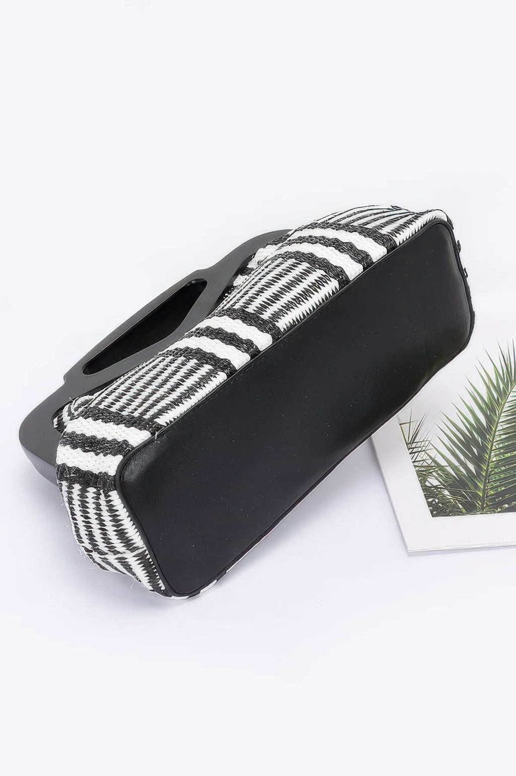 Black faux straw clutch with zebra stripes on handle-side, wood-style frame, open top