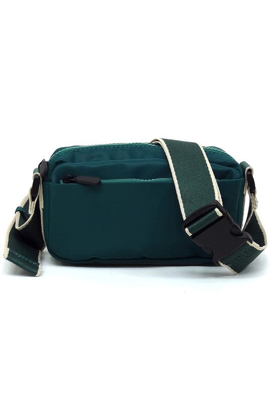 Green nylon crossbody fanny pack with front zip, contrast trim, and adjustable strap