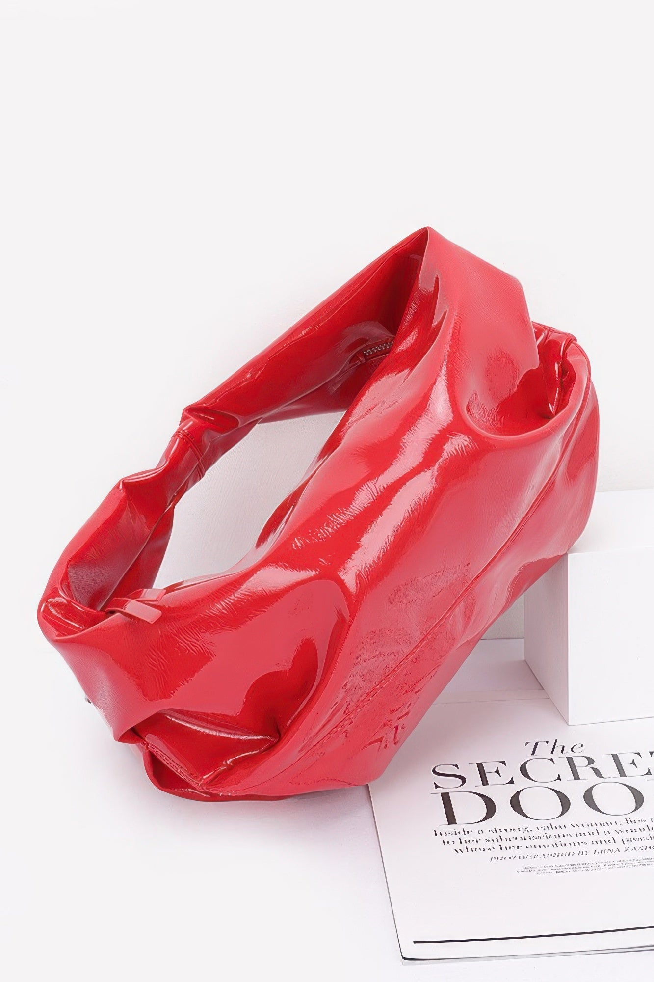 Red patent hobo bag with wide opening, visible interior lining, short strap loops