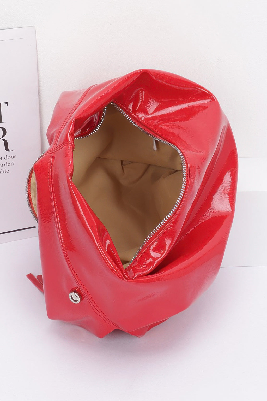 Red patent hobo bag, close-up of top opening and stitched interior
