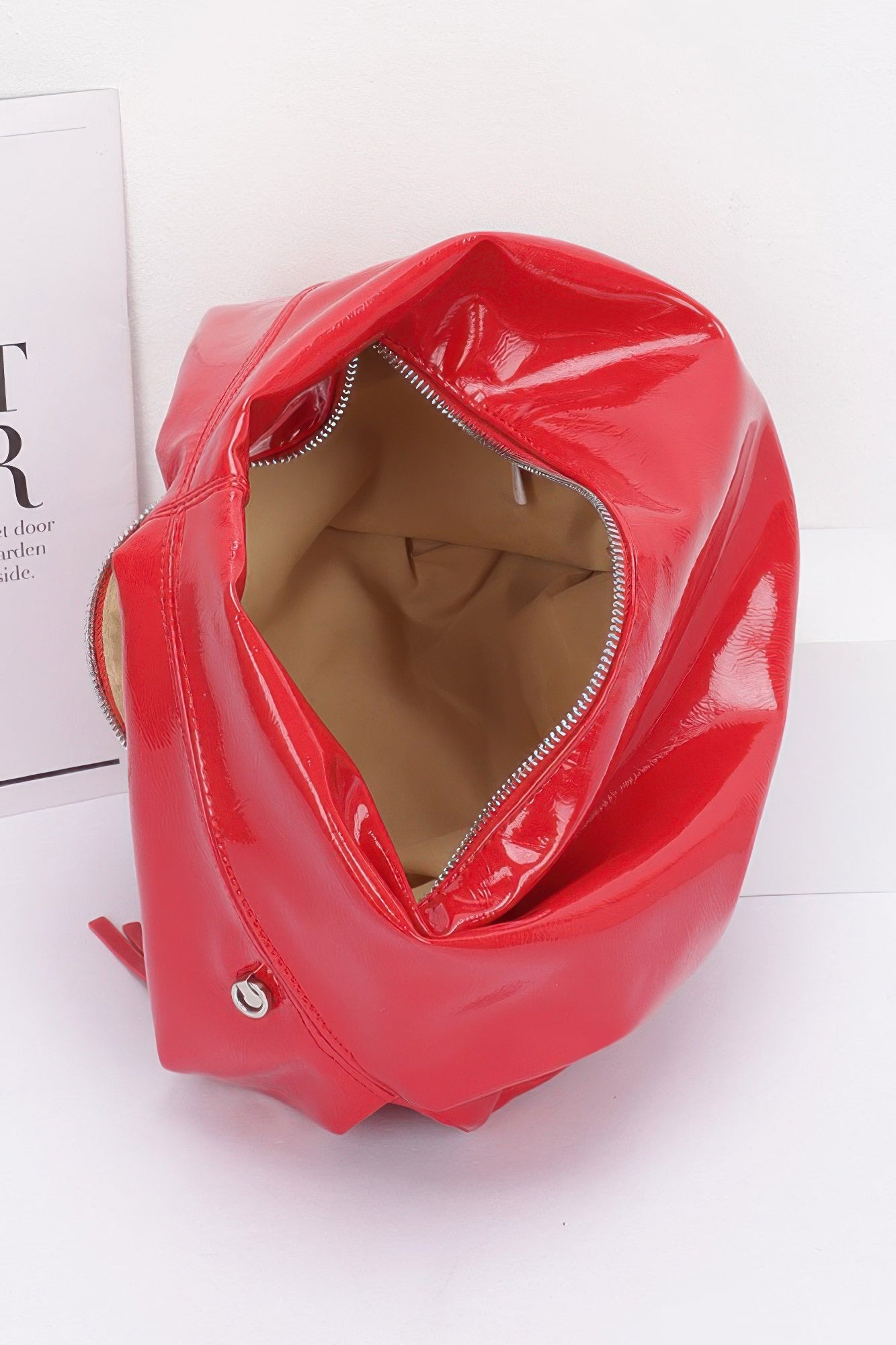 Red patent hobo bag, close-up of top opening and stitched interior