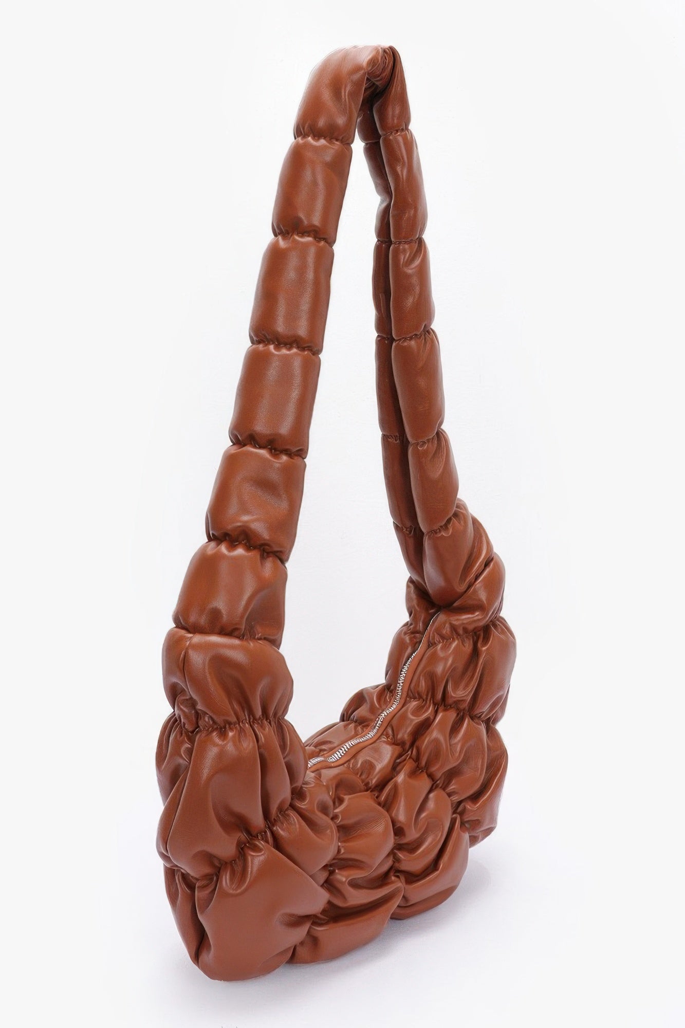 Pleated faux leather crossbody bag, brown, side view of pleated handles and gathered opening