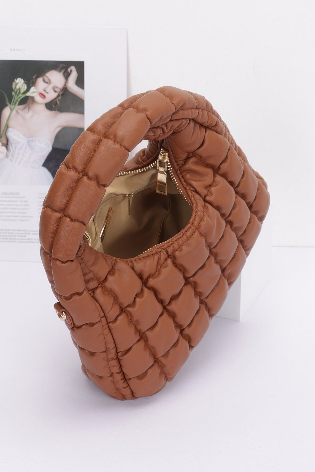 Camel quilted hobo bag with open top showing lining and metal zipper, faux leather padded