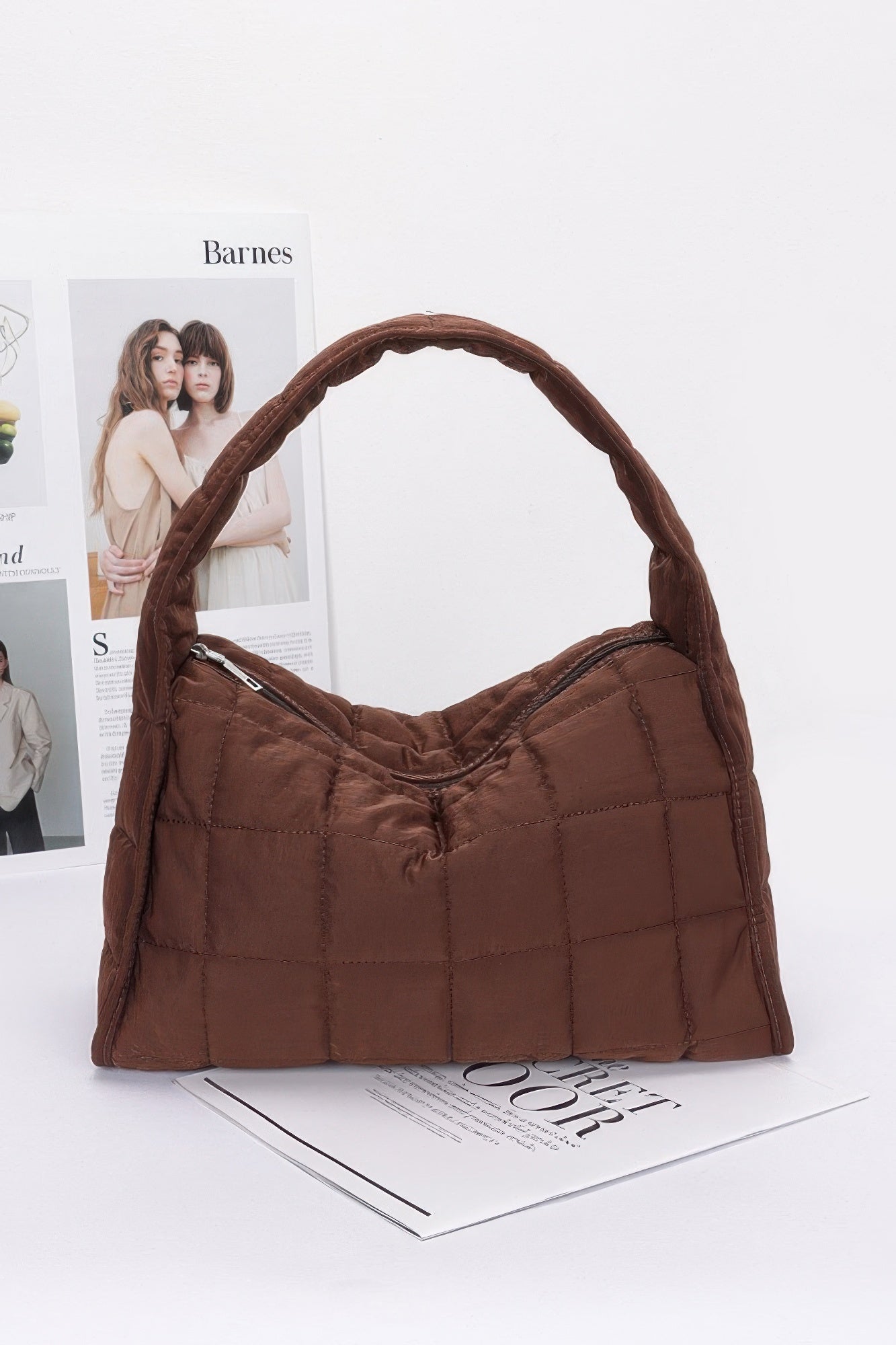 Brown quilted nylon shoulder bag with curved handle and quilted front panel