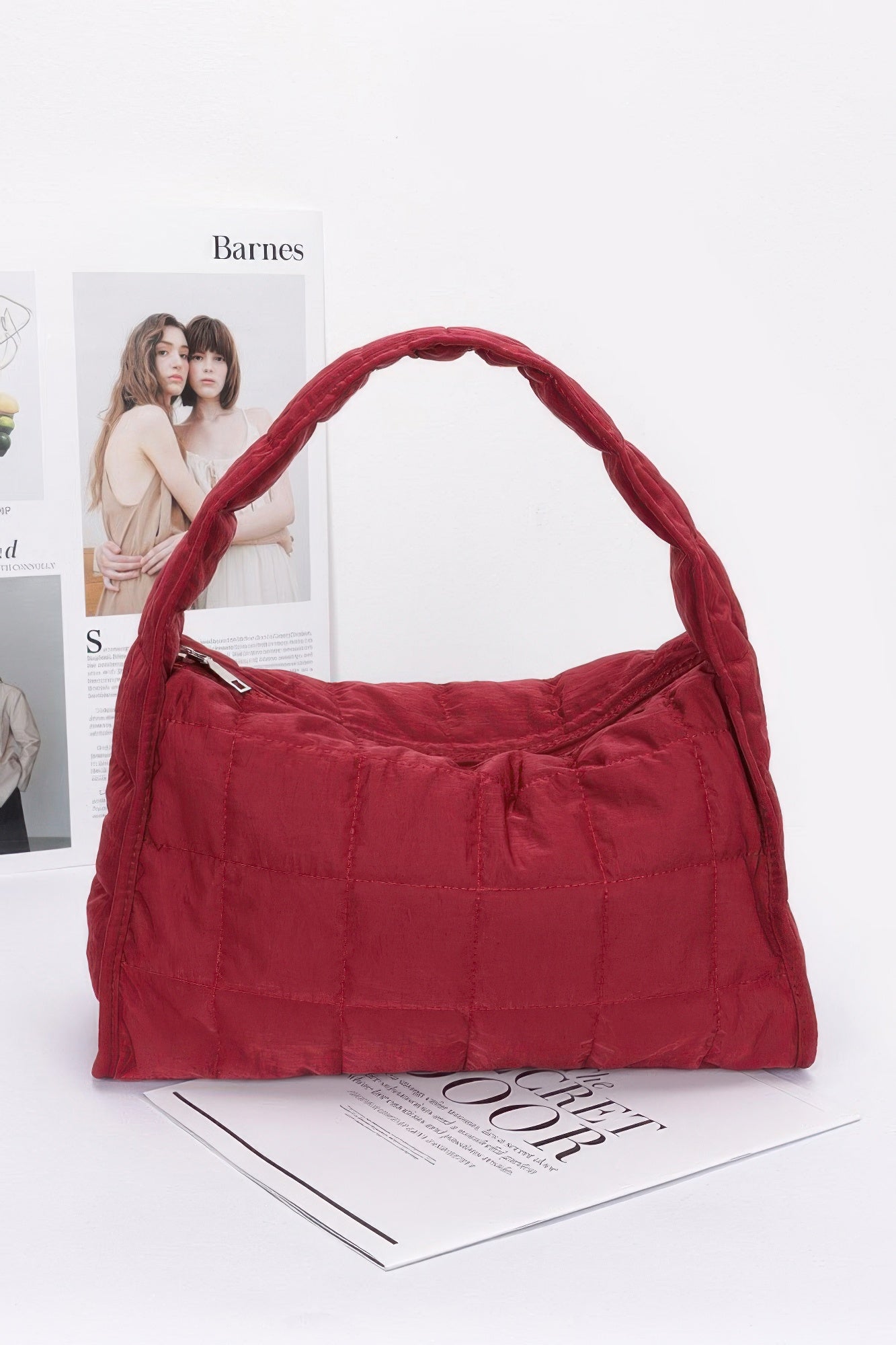 Quilted nylon shoulder bag in burgundy with curved top handle and stitch detailing